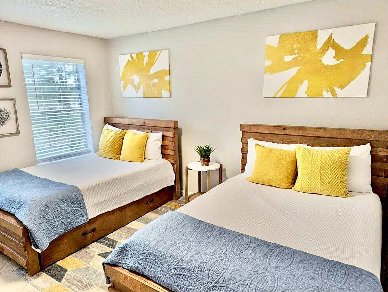 Bright, beachy second bed room with 2 full sized beds and twin trundle