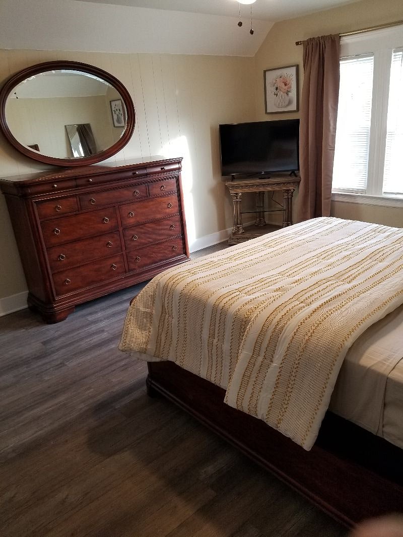 Bedroom #1, queen size bed, dresser, tv stand, 1 side table, closet, ceiling fan, blackout curtains.