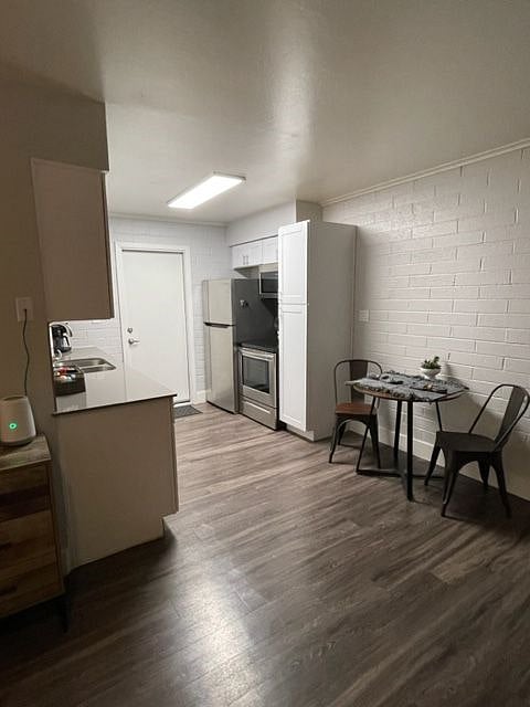 Full sized refrigerator, electric range & over the range microwave, to right a pantry cabinet for food storage