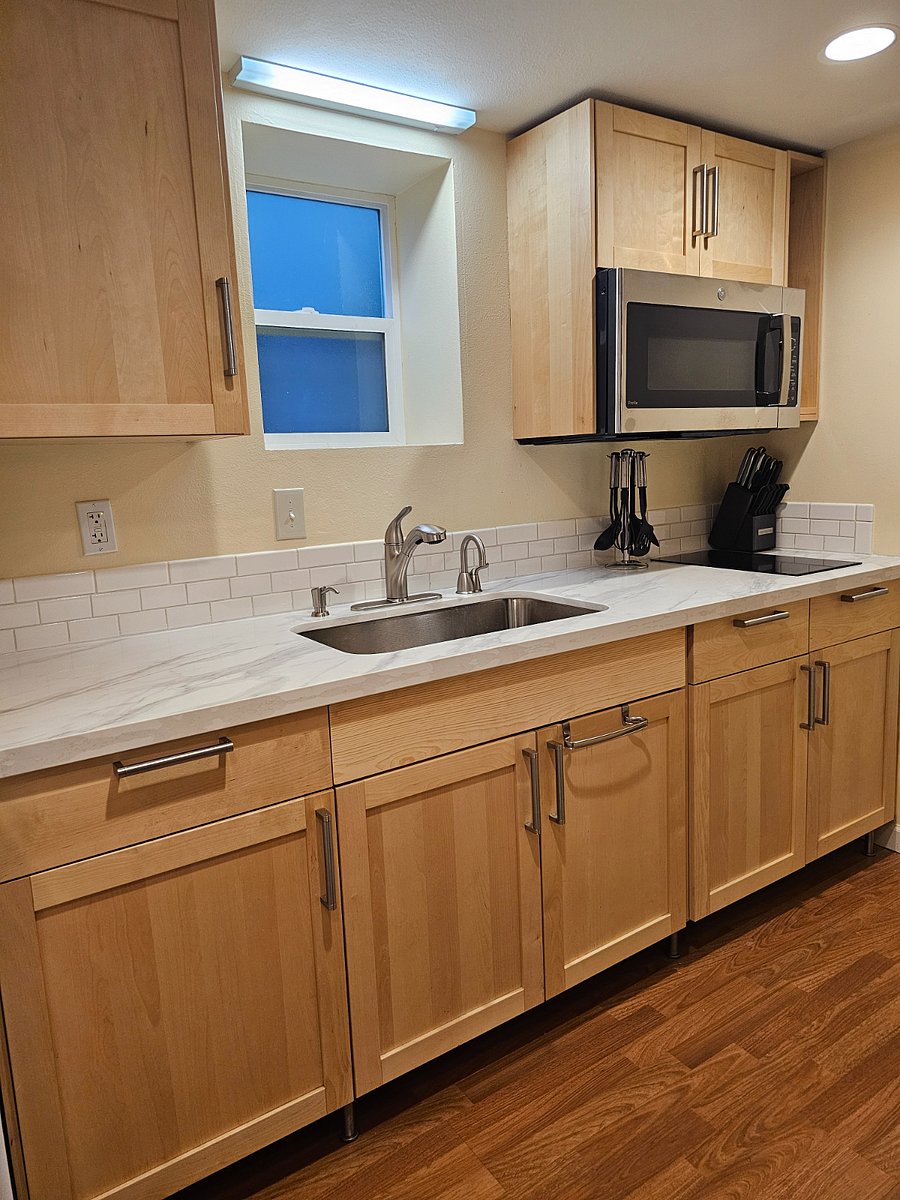 Kitchenette contains insta-hot water for beverages or cooking, garbage disposal, induction two-burner cooktop, and OTR convection microwave