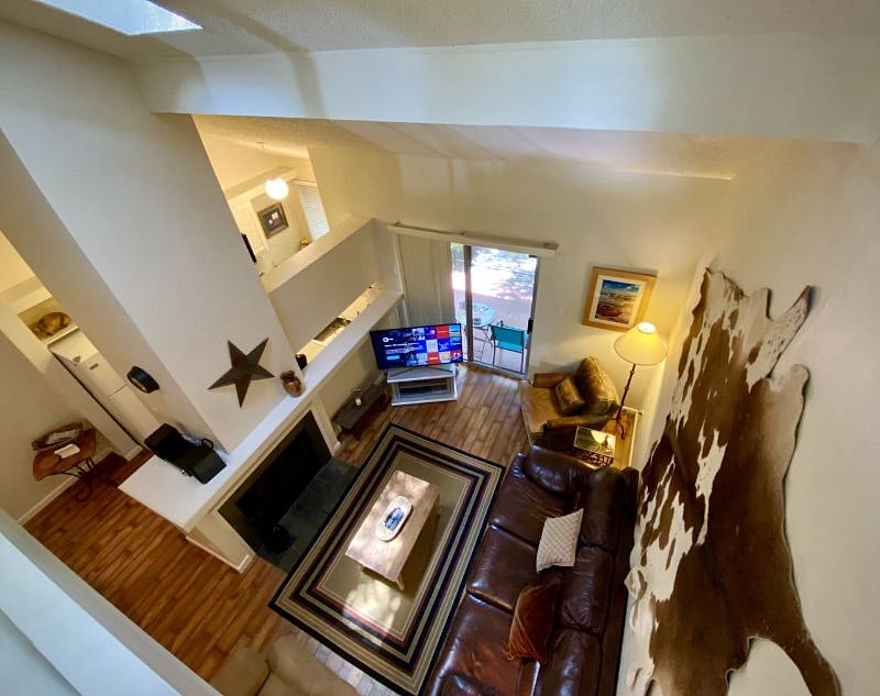 The view of the living room from the loft upstairs. please note, the TV has been moved to the fireplace and there is a little 2 seat bar where the cupboards were removed. Pictures will be updated when the tenant leaves!