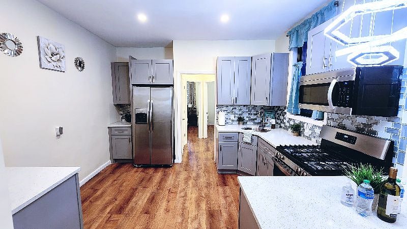 Full size stainless steel appliances and kitchen equipped with cookware, dinnerware, baking sheets, blender and toaster