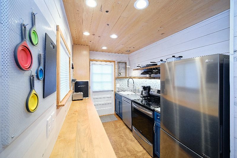 Fully stocked galley kitchen with full-sized refrigerator, stove/oven, dishwasher, and microwave.
