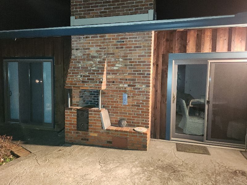Outdoor fireplace and apartment patio doors.