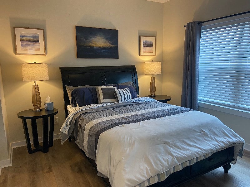 Large beautiful neutral bedroom with comfortable queen bed with storage,