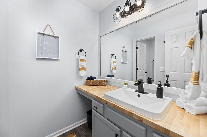 Master bathroom with butcher block counters and a bathtub and shower