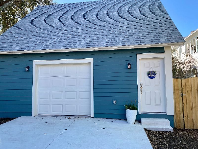 This is the concrete parking pad. You parallel park here in front of the garage door and enter through the door on the right. The garage is a finished space where my husband brews beer and films YouTube videos.