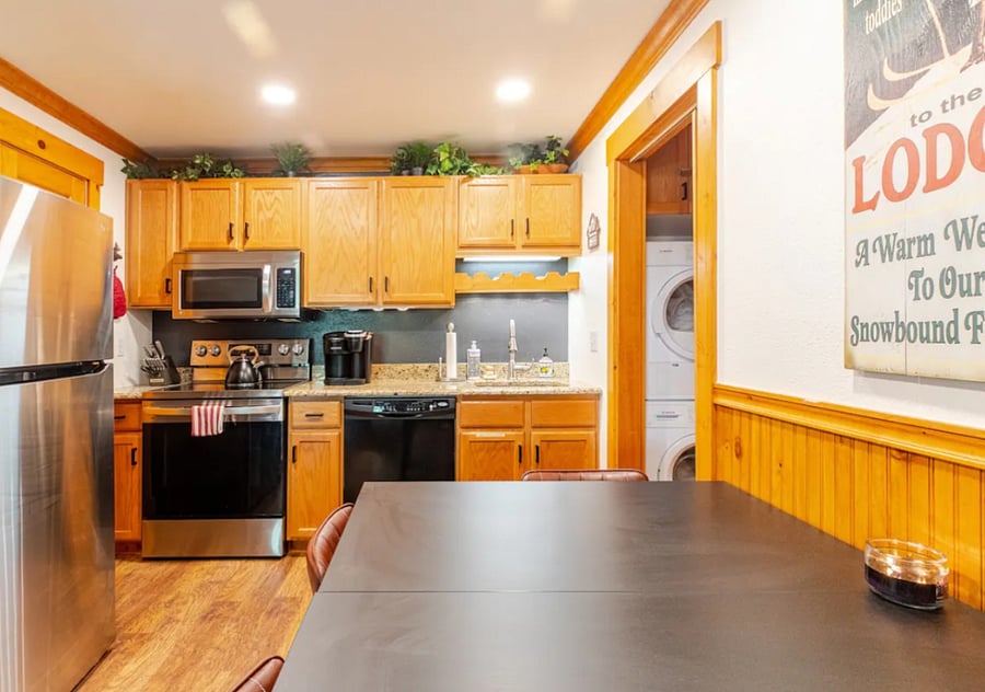 Kitchen with microwave, dishwasher stove top oven, refrigerator, coffee maker, tea kettle, sink, dining area, pantry and cabinets fully stocked with everything you need to cook most meals.