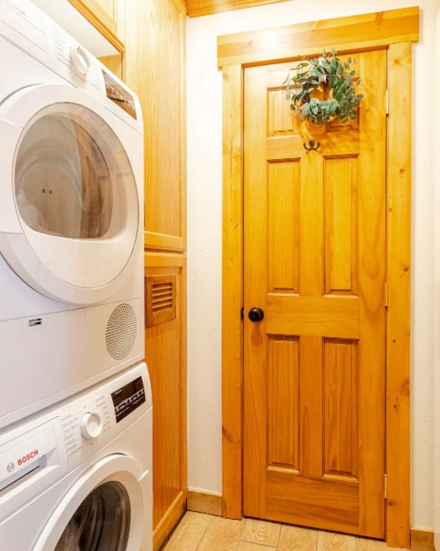 Laundry room with washer, dryer, detergent, pool towels, iron, and more.