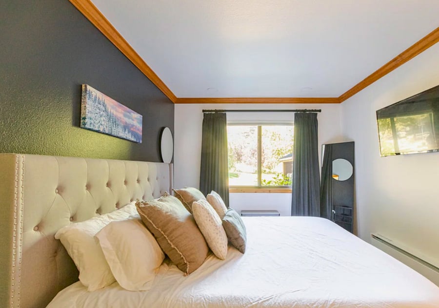 King bed in main bedroom, tv with streaming, insulated black out drapery, built in closet with drawers, shelves, & hangers for wardrobe, and a built in wall heater for comfort. Fan provided for summer months.