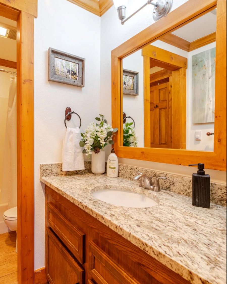 Bathroom and powder room with shower, bathtub, toilet, sink, stocked with towels, shampoo, conditioner, body wash, and hair dryer.