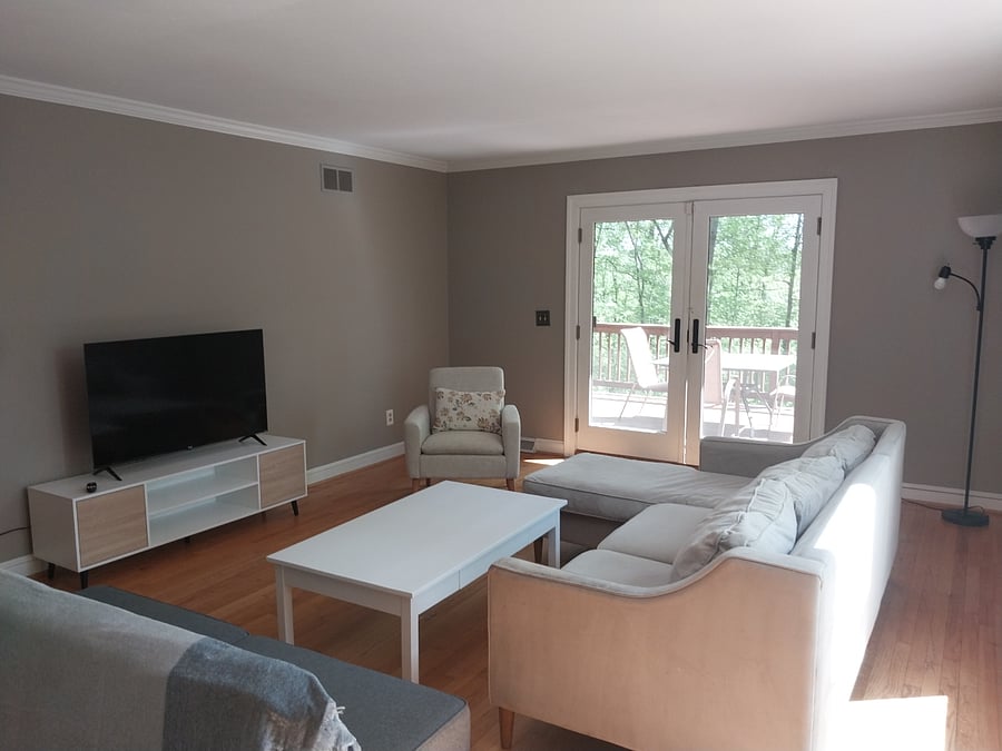 Living room has a smart TV and great views of the woods.