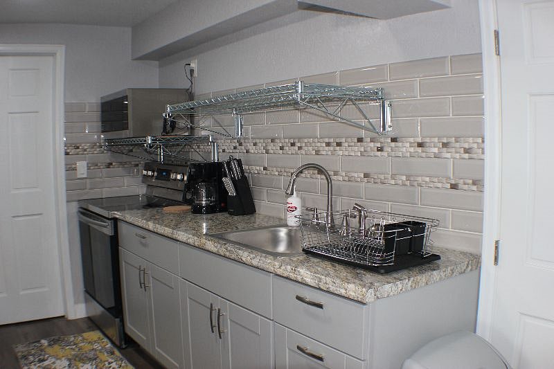 Kitchen with stove and microwave, also pictured is knife block