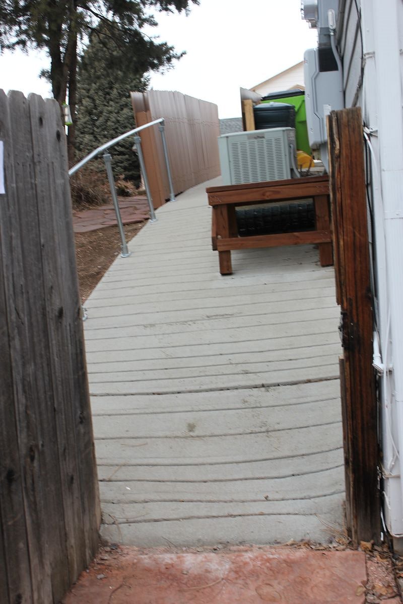 Path with rails up side of house from apartment