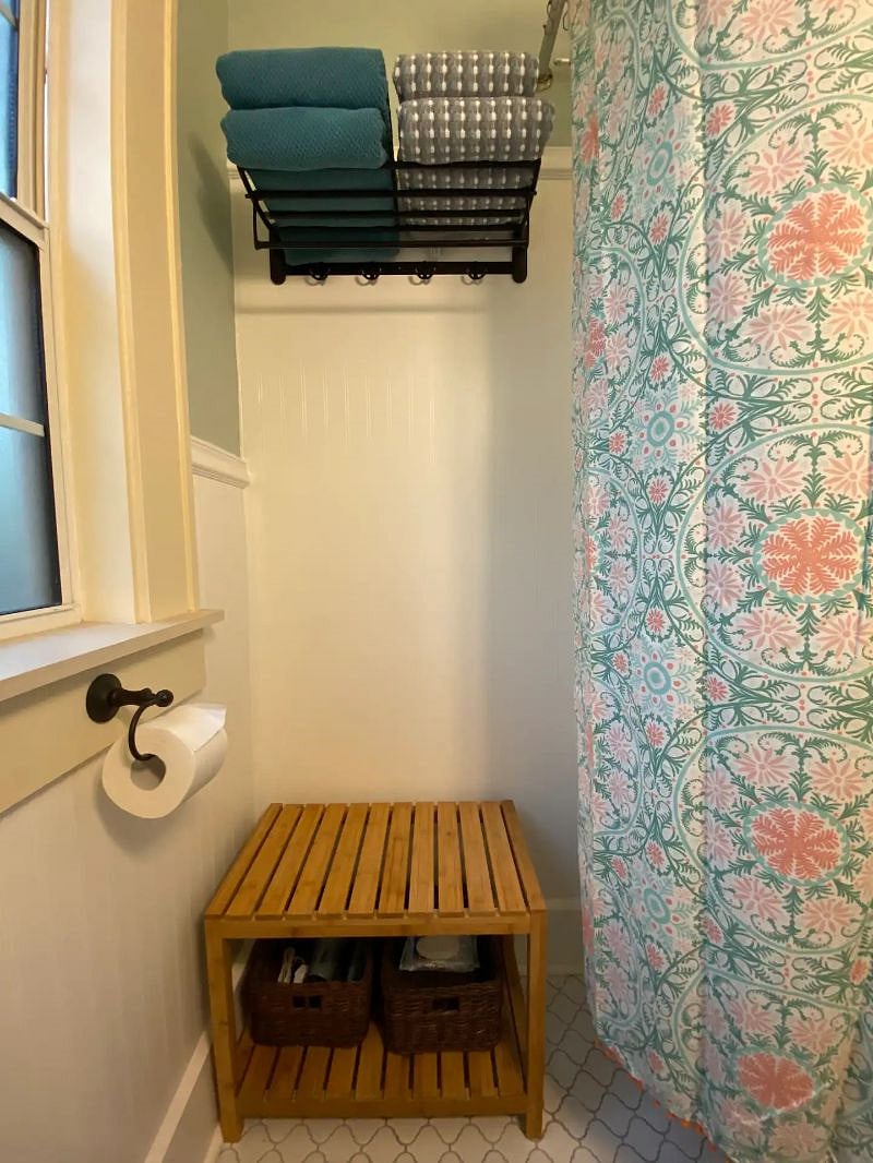 Bathroom towel rack, bench, bins with hair dryer.