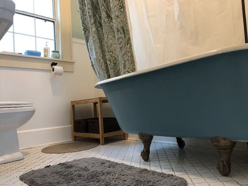 Original claw foot tub in bathroom.