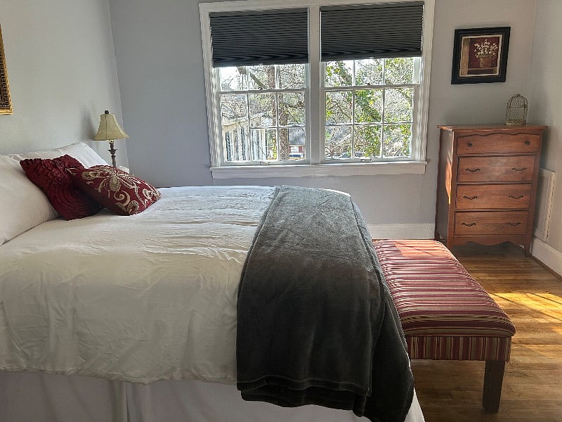 Queen size bed, black out blinds, and ceiling fan
