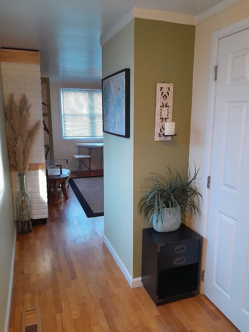 Standing at the entry door, facing bathroom door and hall leading to main space.