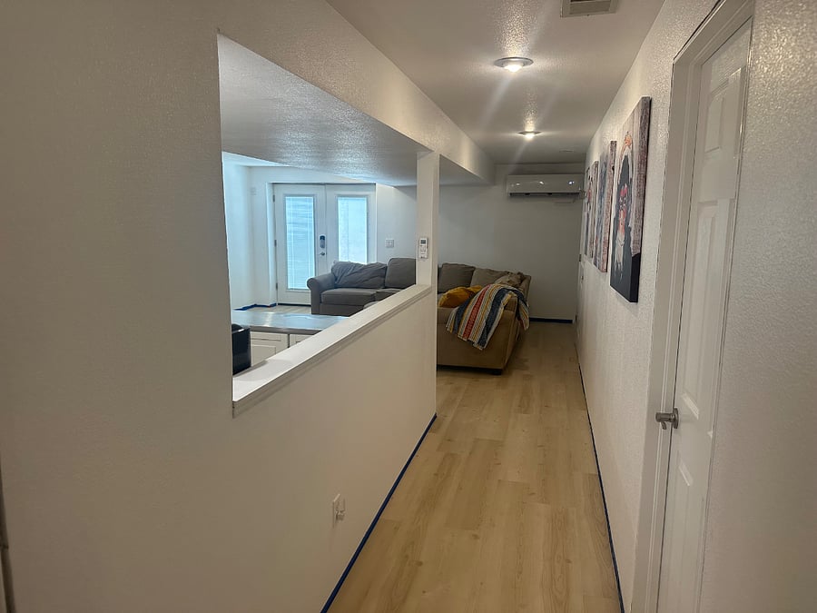 New LVP flooring install installed will update with baseboards once installed.  View of the entry with blinds inside glass.  The end of the hallway behind this photo has 1 shower room and 2 bedrooms. 