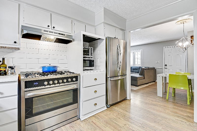 Kitchen features stainless steel appliances with 36 inch gas range. 