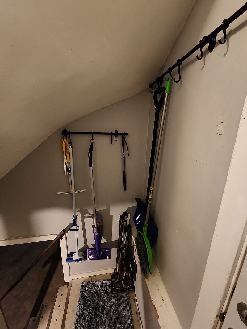 Stairs to laundry/basement storage
Vacuum, swifter duster, mops, broom and shovel for winter season hung and stored here.