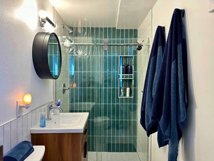 Bathroom mirror opens for extra storage. Hangers on wall for towels and two niches in the shower make getting ready for the day easy!