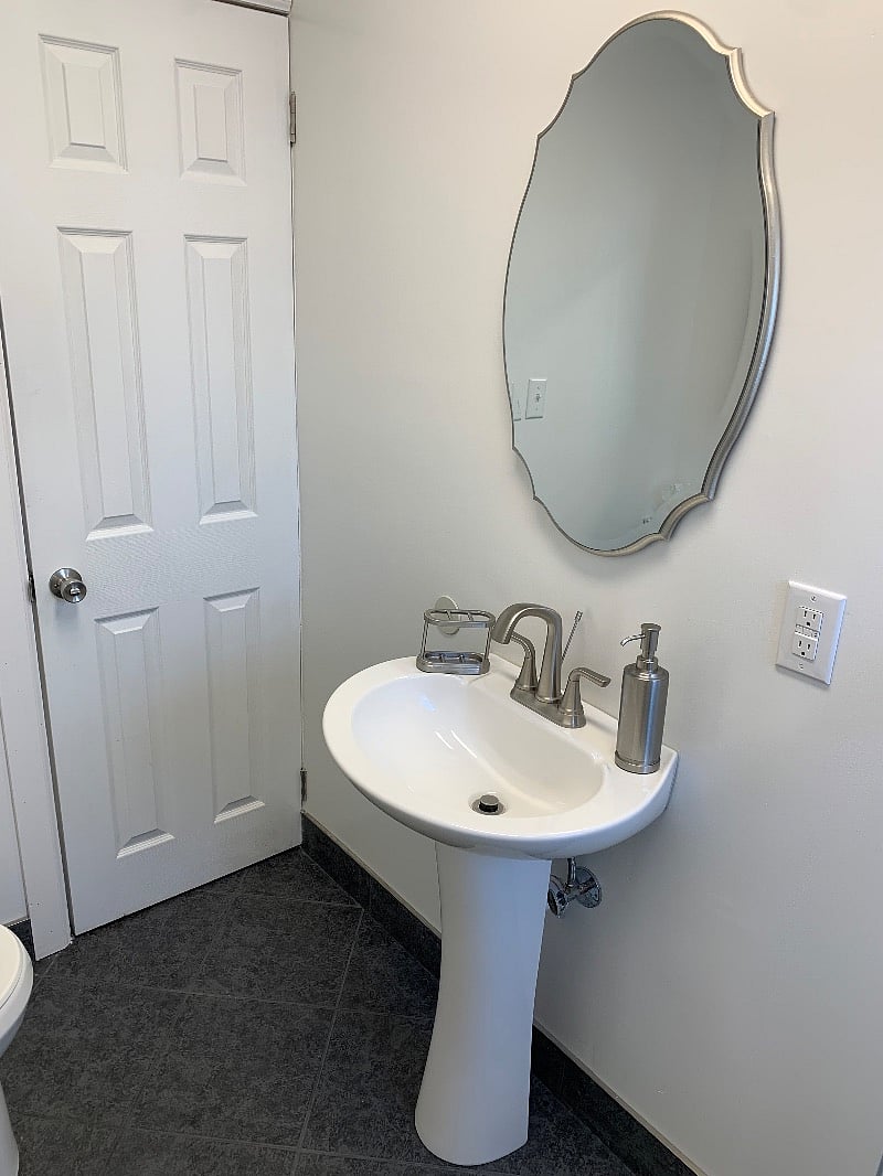 Bathroom sink, soap dispenser, toothbrush holder, and mirror.