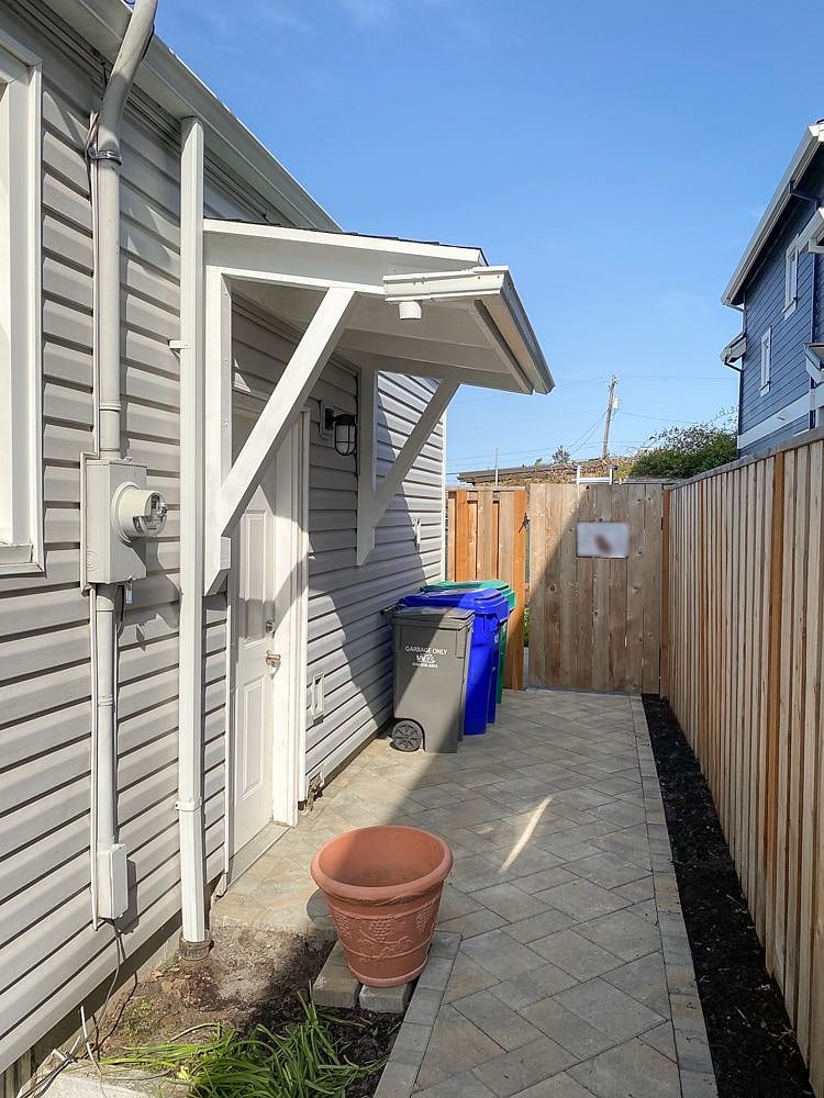 Entrance to unit at side of building; immediate flight of stairs down from the door