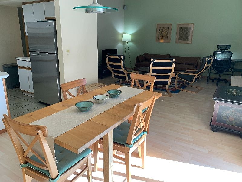 Dining table with kitchen on left and living room beyond