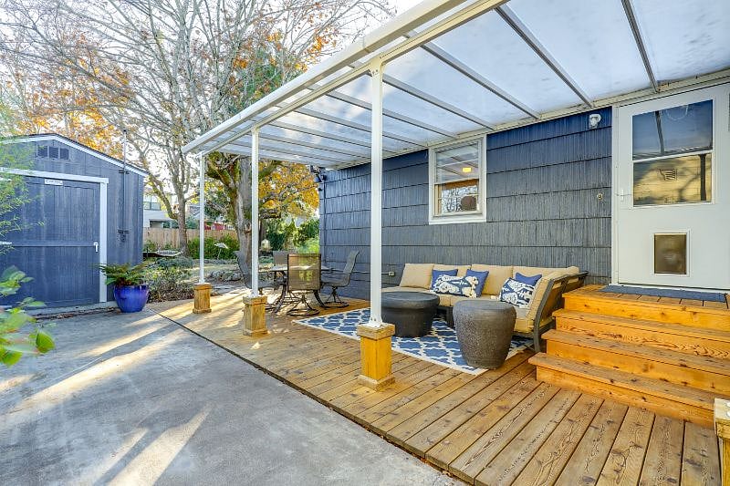 Spacious covered outdoor area with dining table & couch seating.