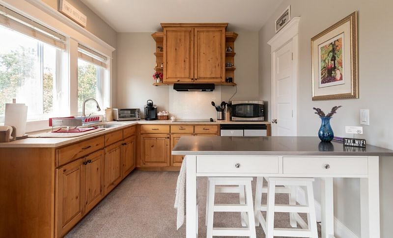 Kitchen with table, Keurig, cooktop, Ninja airfryer/toasteroven combo, microwave/convection oven, and undercounter fridge/freezer