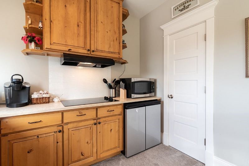 Kitchen with table, Keurig, cooktop, Ninja airfryer/toasteroven combo, microwave/convection oven, and undercounter fridge/freezer