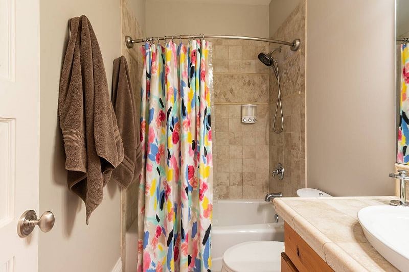 Bathroom featuring toiletries in a dispenser, soft towels, and a hair dryer for your stay
