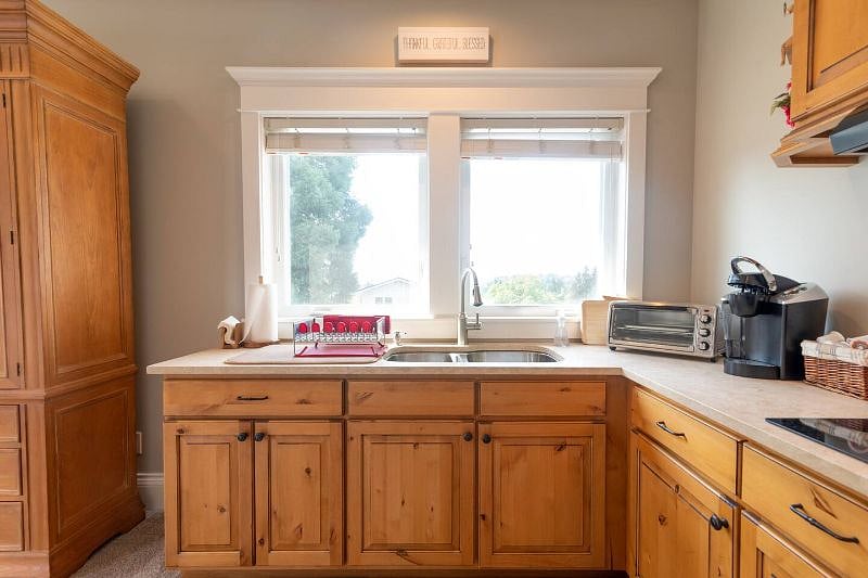 Kitchen with table, Keurig, cooktop, Ninja airfryer/toasteroven combo, microwave/convection oven, and undercounter fridge/freezer