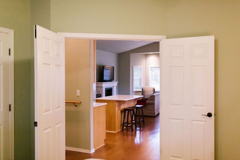 Looking out to main kitchen and living space from double doors in bedroom