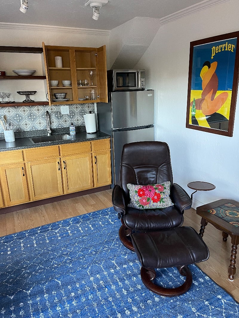 The Perrier original advertising poster is from 1964 France. This main room has a ceiling fan and wall heater. 
