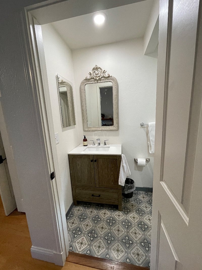 The bathroom is small but very cute with new mosaic floor tile, new vanity with quartz top, large medicine chest and an antique French mirror and bright LED lights.  