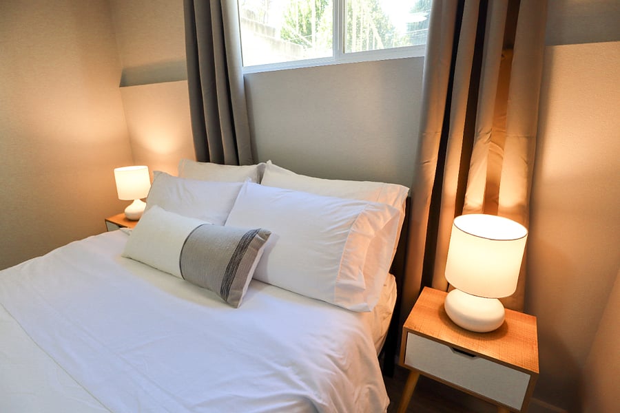 Extra pillows, two end tables, and two desk lamps