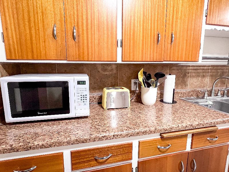 Microwave, toaster, and utensils.