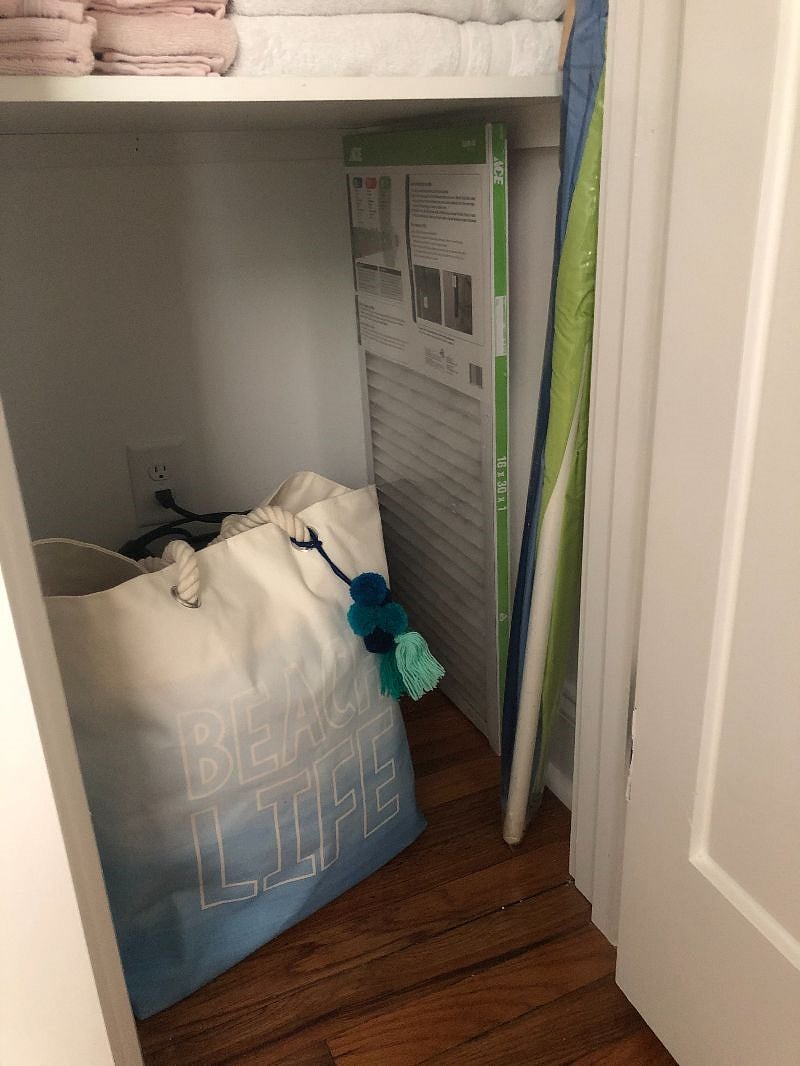 Linen closet holds beach umbrella and beach bag complete with four beach towels and a beach blanket
