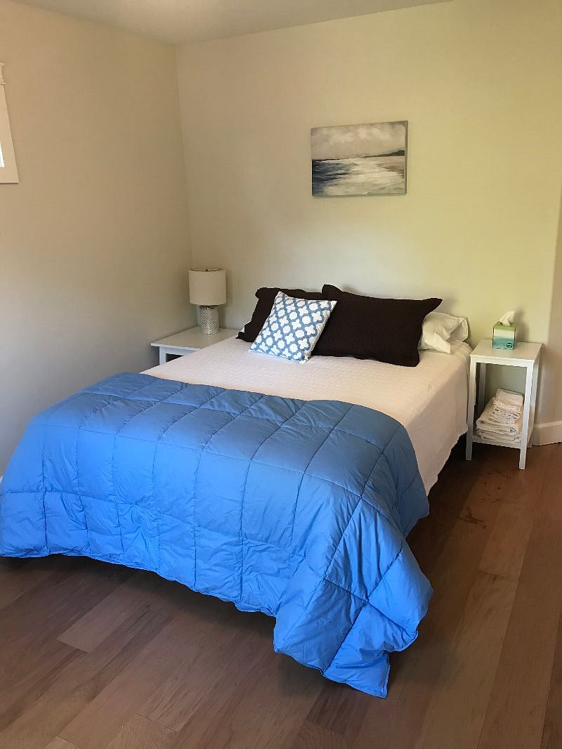 Upstairs bedroom #2 with queen bed. Full closet with hangers, a 3 drawer white dresser, and suitcase stand.