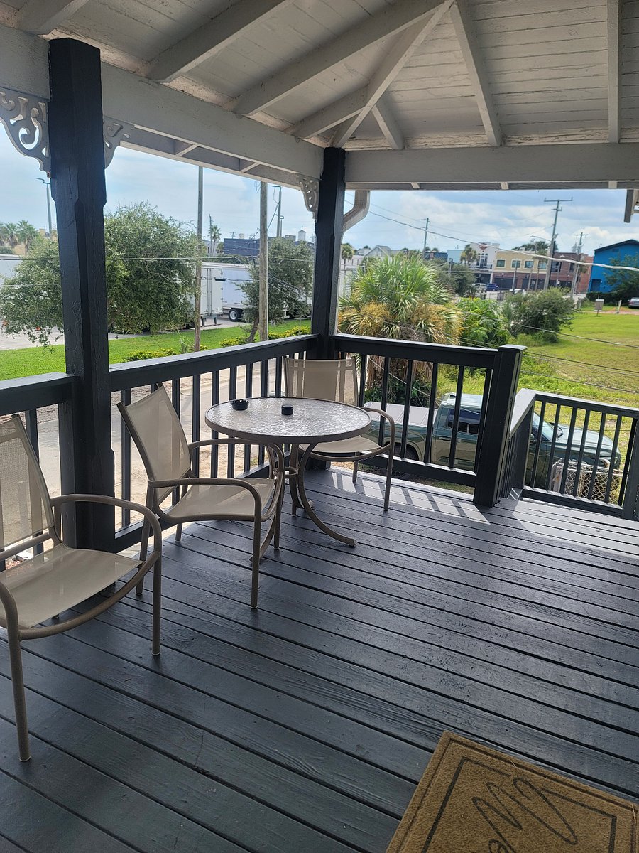 Patio tables and chairs in front of apt with Peabody parking lot & Main Street & ocean in background.