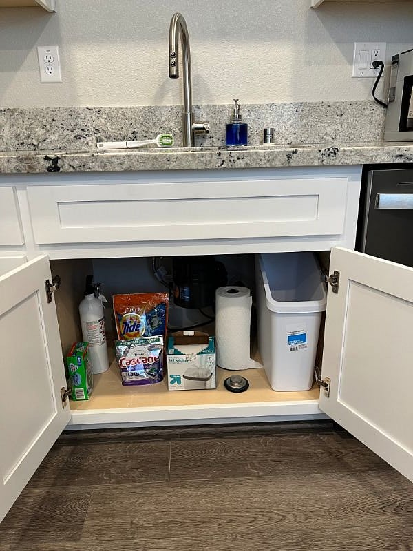 under the sink garbage can, with cleaning supplies and laundry detergent