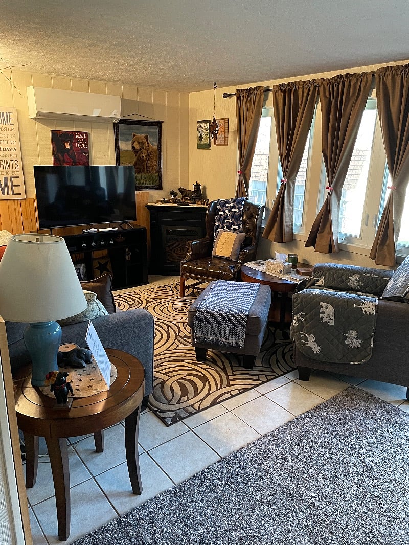 Living area with Smart Direct TV, AC, Electric Fireplace, Comfy Couch, and Chairs.