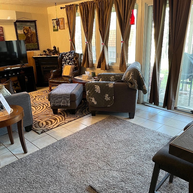 Living area with Smart Direct TV, AC, Electric Fireplace, Comfy Couch, and Chairs.