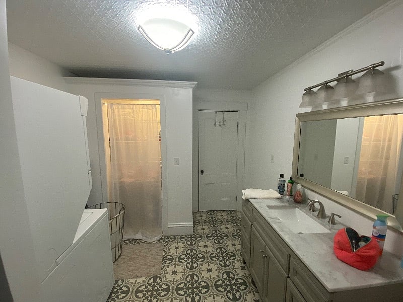 Newly remodeled bathroom with shower, linen closet, and laundry machines