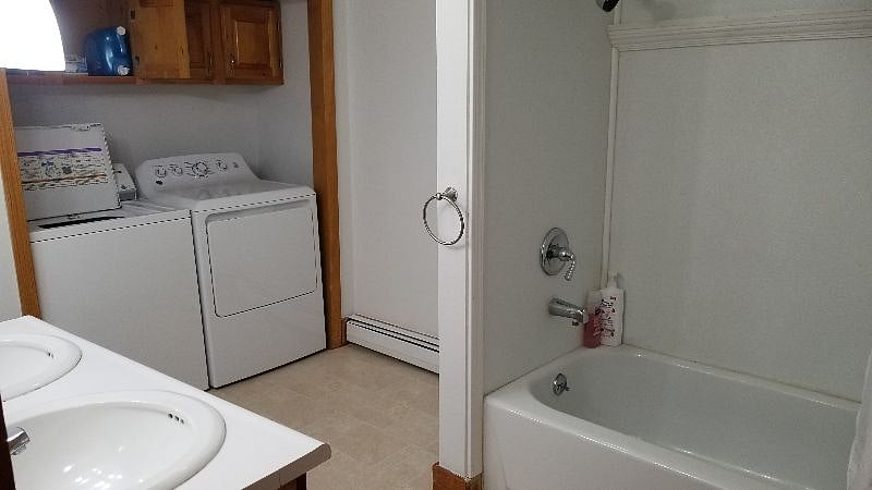 washer and dryer in bathroom on second floor with bathtub/shower combo