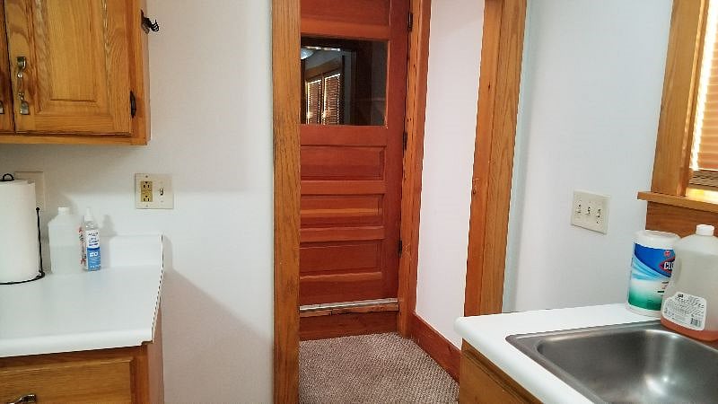 doorway to stairs leading to the second floor with pantry door in the background