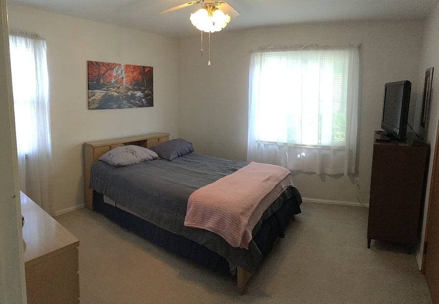 Summertime capture entrance view of Main floor bedroom with full size bed and 32' Smart TV