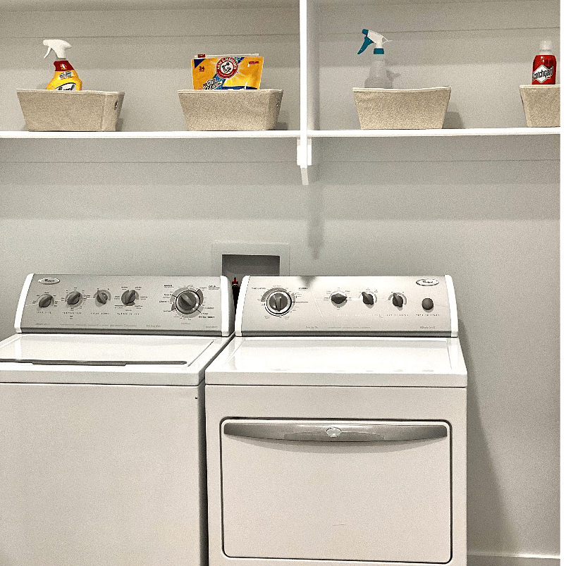 Full size Washer Dryer with ironing board soap and cleaning supplies